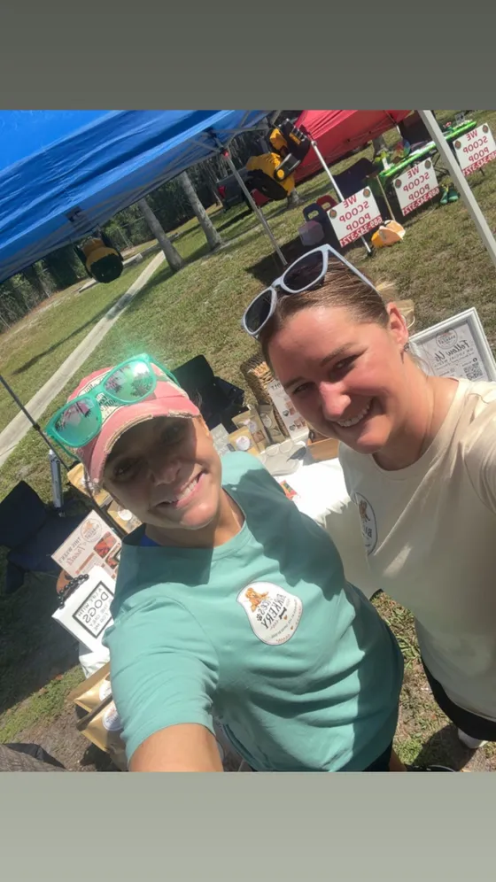Katrina and a friend smiling at the booth
